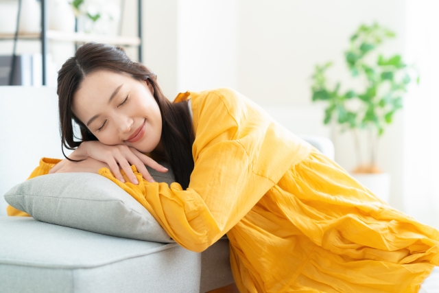 眠っているオレンジの服を着ているロングヘアの女性の写真
